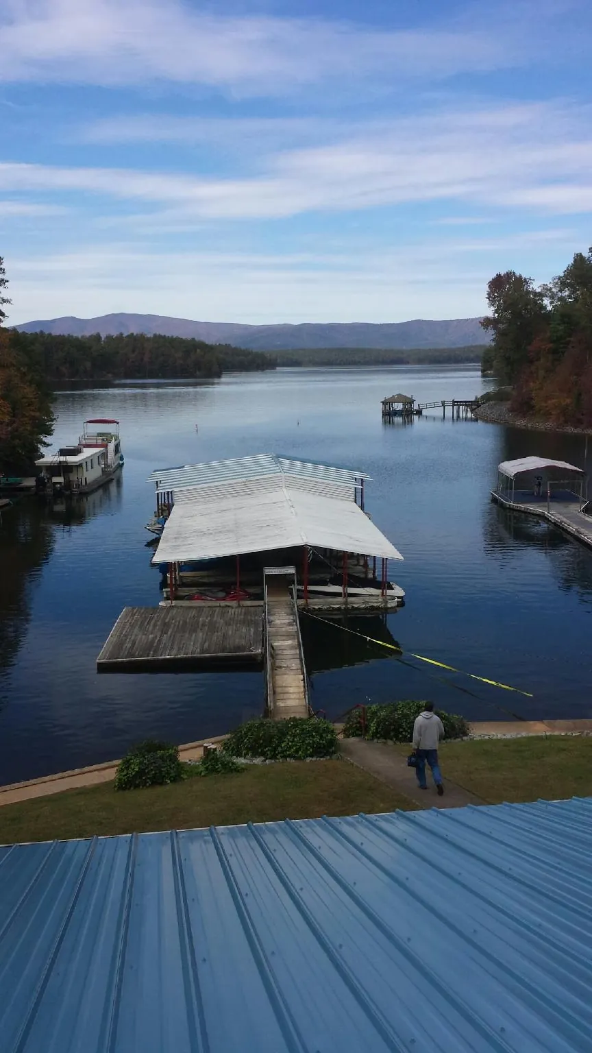 View across a lake from a newly installed blue metal roof in Clarksburg