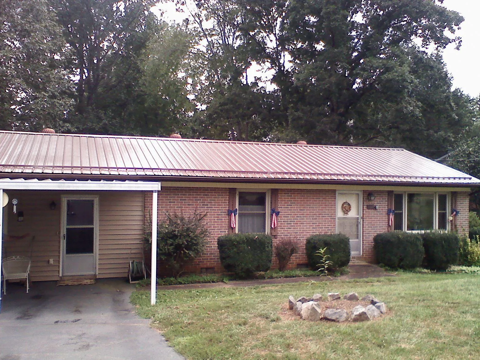 Bronze metal roof and carport on a brick ranch home — Roof Repair work by our crew in Clarksburg